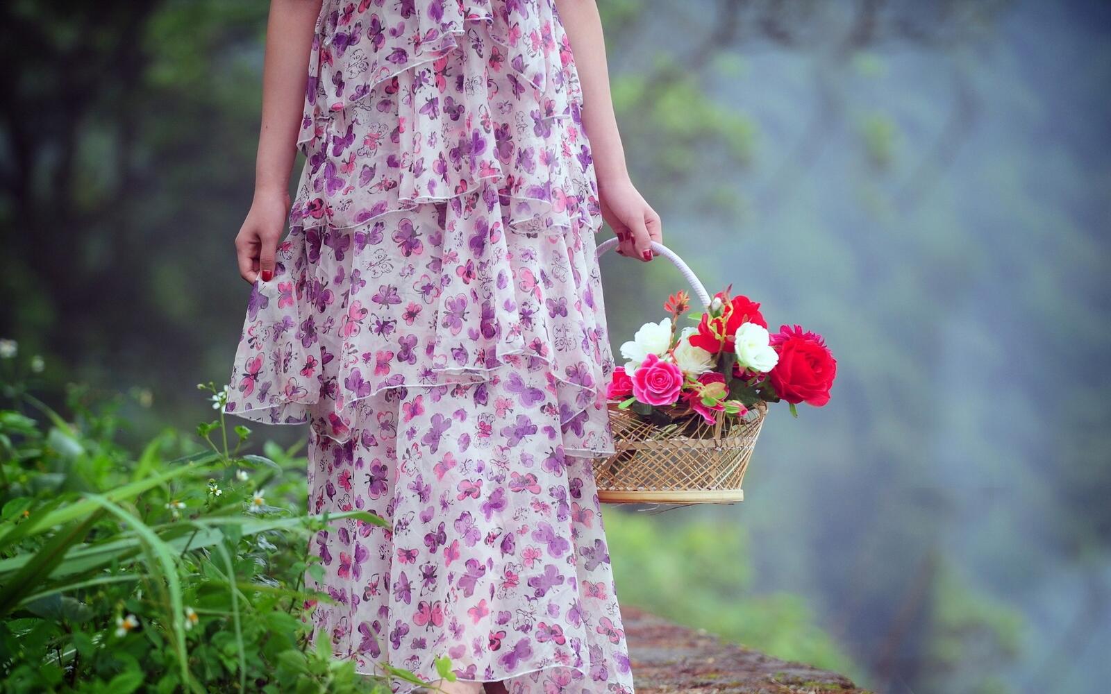 Free photo Girl in a pink dress with a basket of flowers