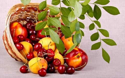 Healthy food basket consisting of apples with peaches and cherries
