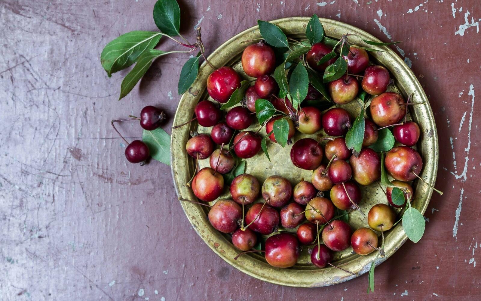 Бесплатное фото Яблоки с вишнями в круглой тарелке