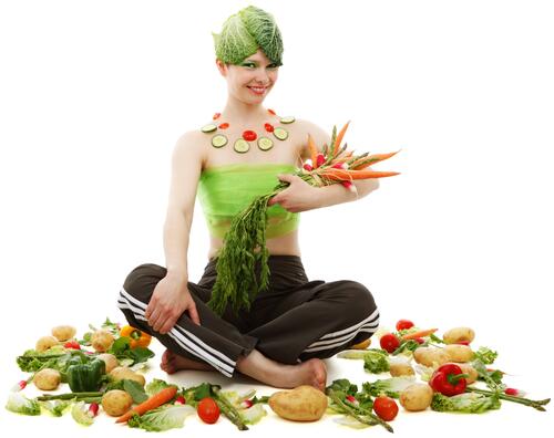 The girl`s sitting there with the vegetables.