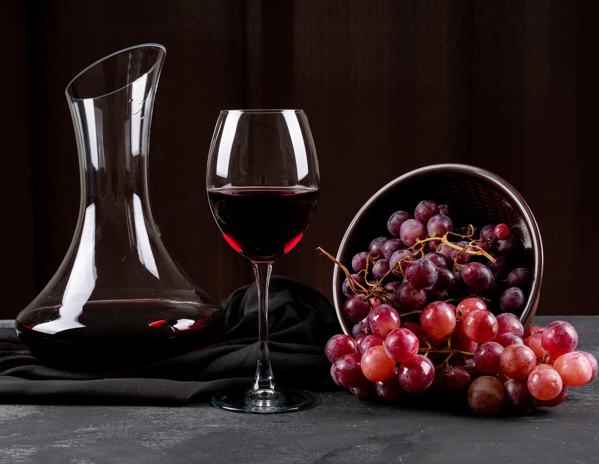 Wallpaper with red wine in a glass and with red grapes