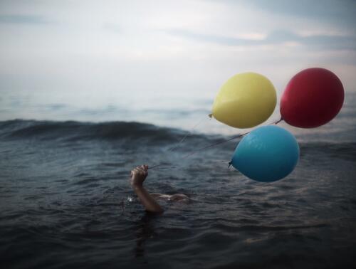 Swimming in the sea with balloons.