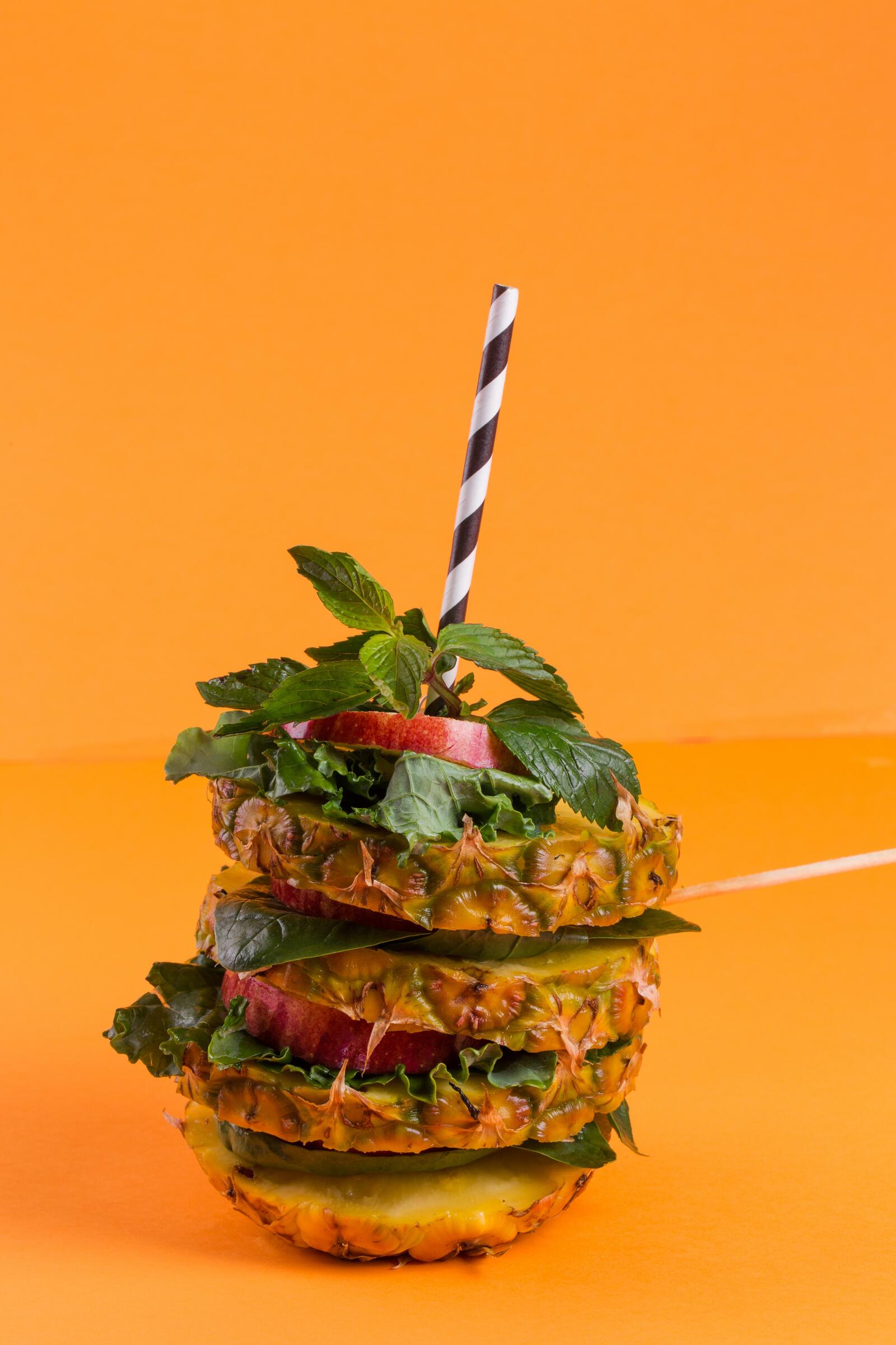 Free photo Pineapple with herbs and cocktail straw