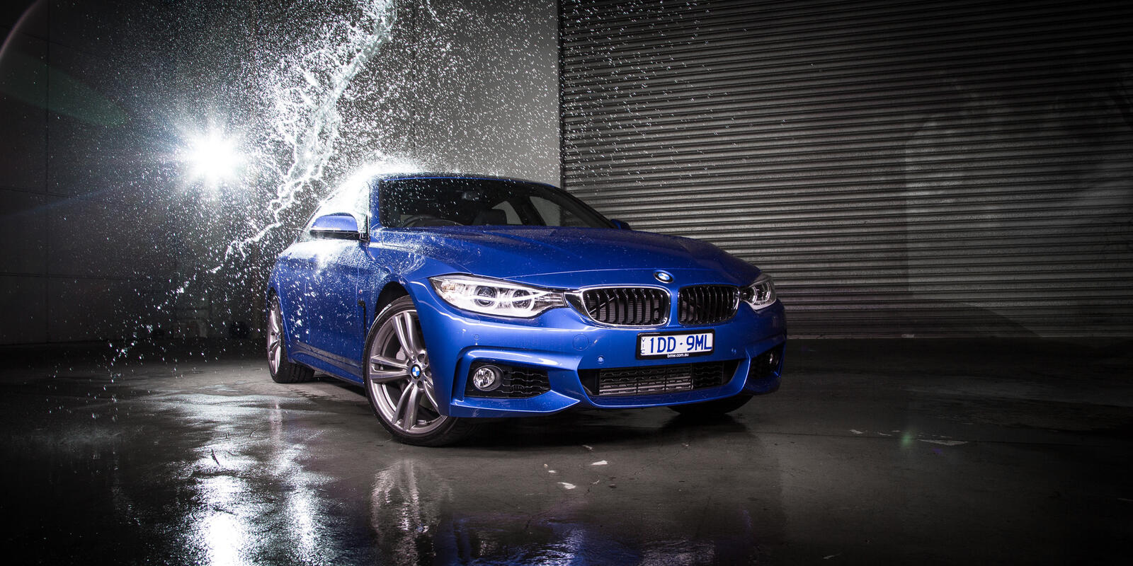 Free photo Water splashes into a blue BMW Gran Coupe 4-series F36