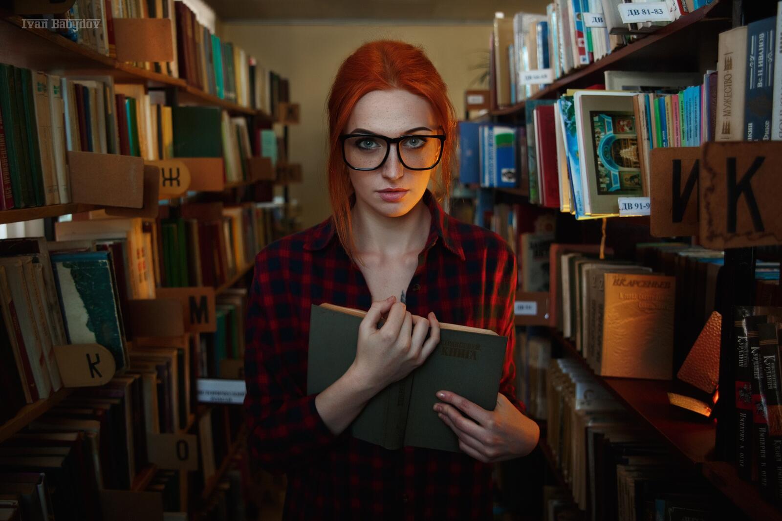 Бесплатное фото Рыжеволосая девушка в библиотеке