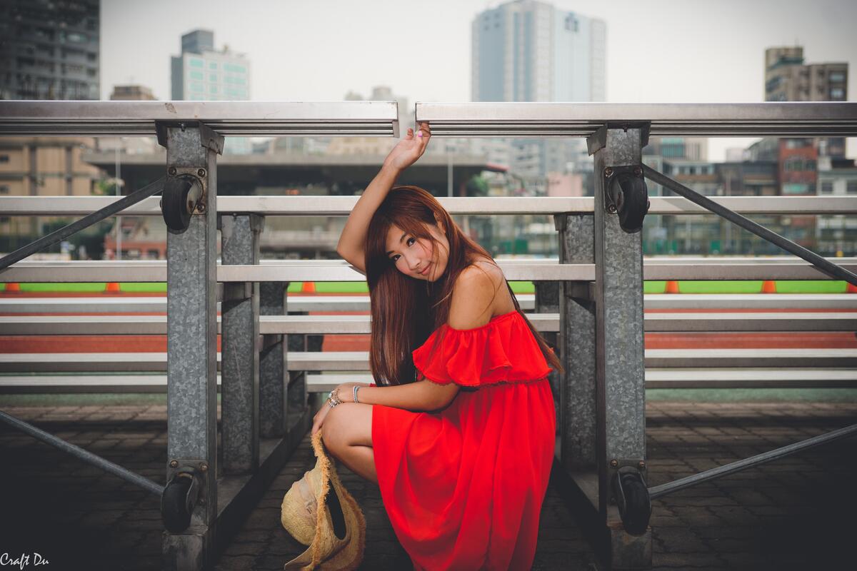 Азиатка в красном платье со шляпой
