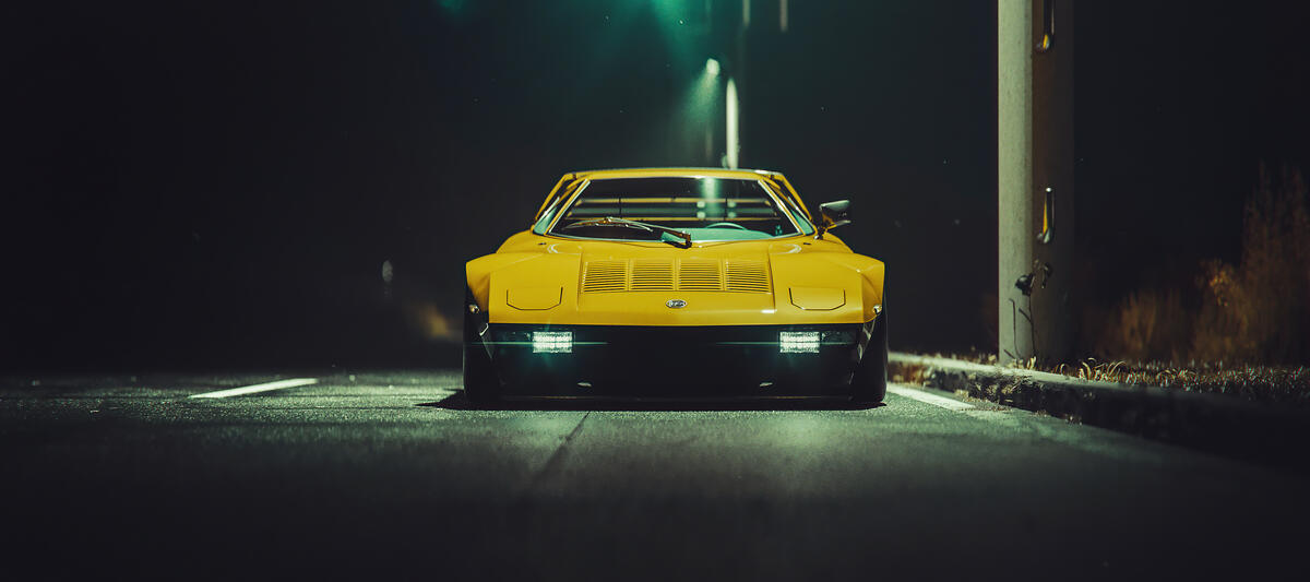 Yellow Mazda RX7 at night under a streetlight