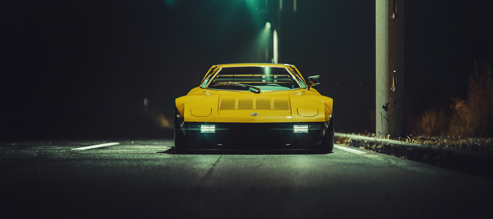 Free photo Yellow Mazda RX7 at night under a streetlight