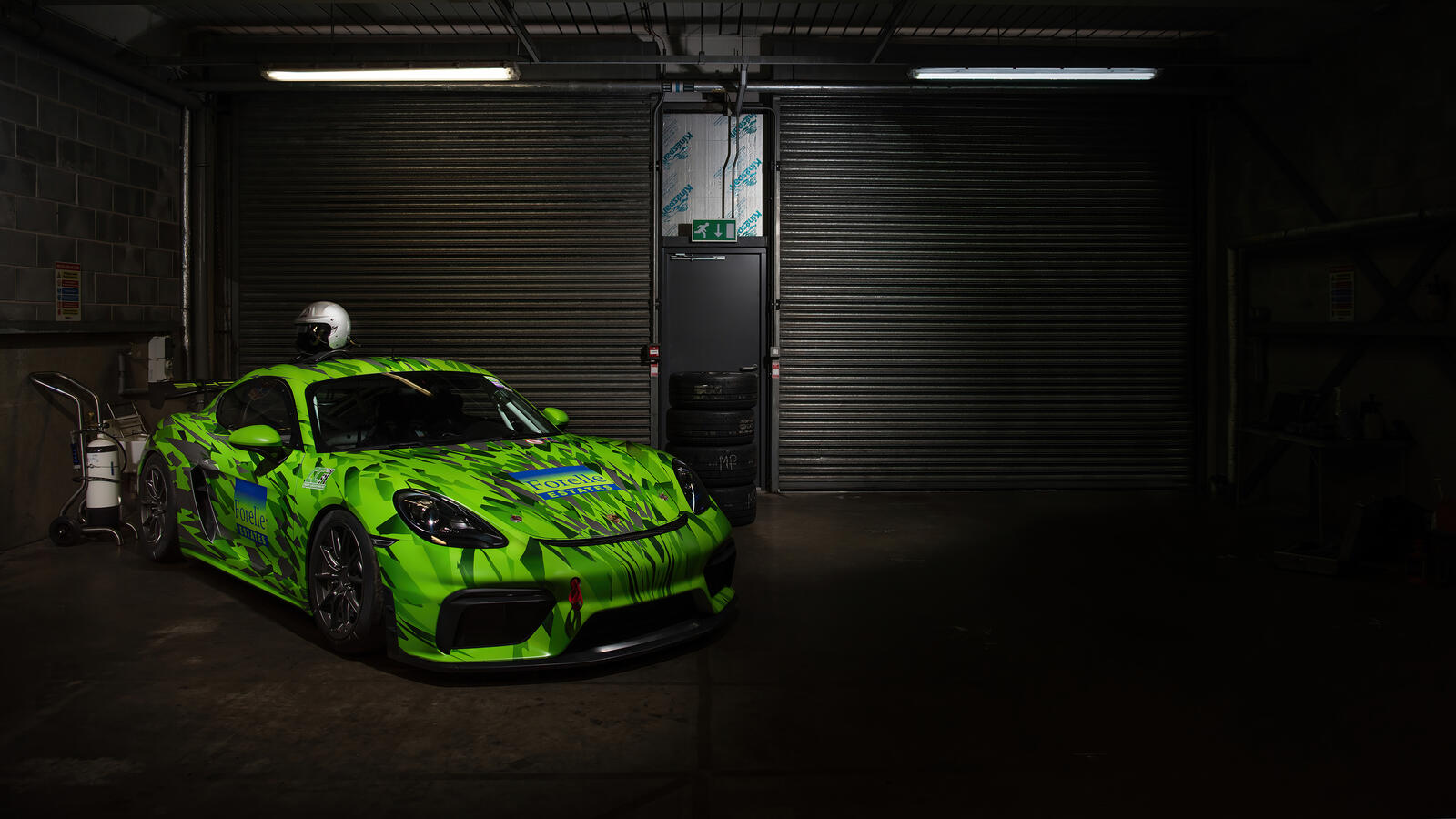 Бесплатное фото Салатовый Porsche Cayman стоит в темном гараже