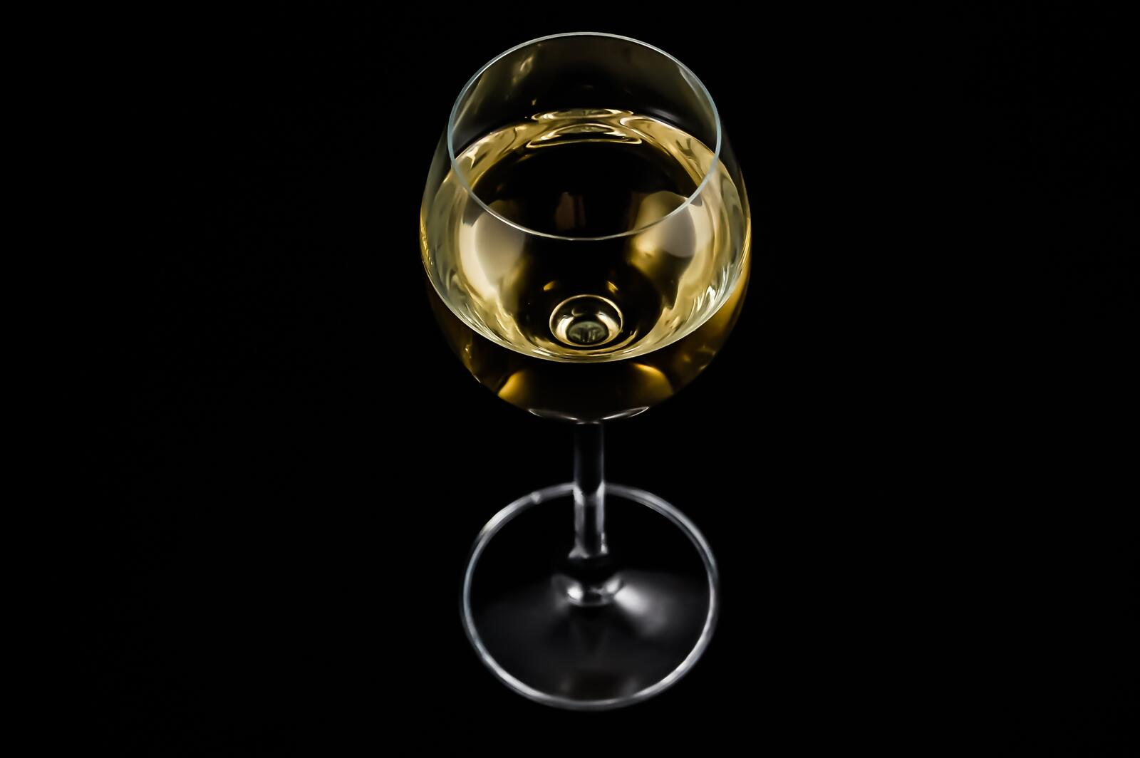 Бесплатное фото Бокал белого вина на черном фоне