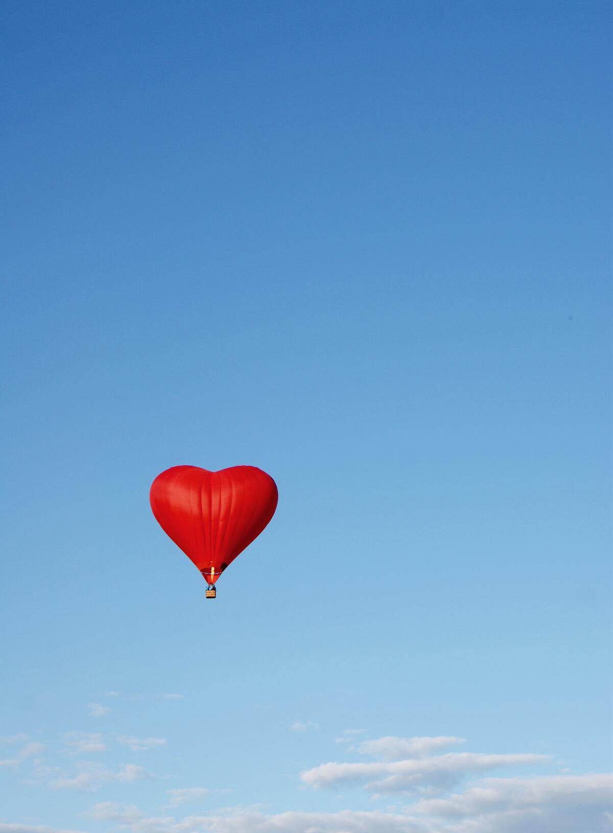 Wallpaper with a red balloon in the shape of a heart