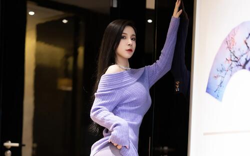 Chinese girl Jommy in a purple dress poses next to a painting