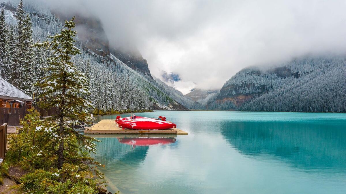 Красная байдарка на голубом озере в горах