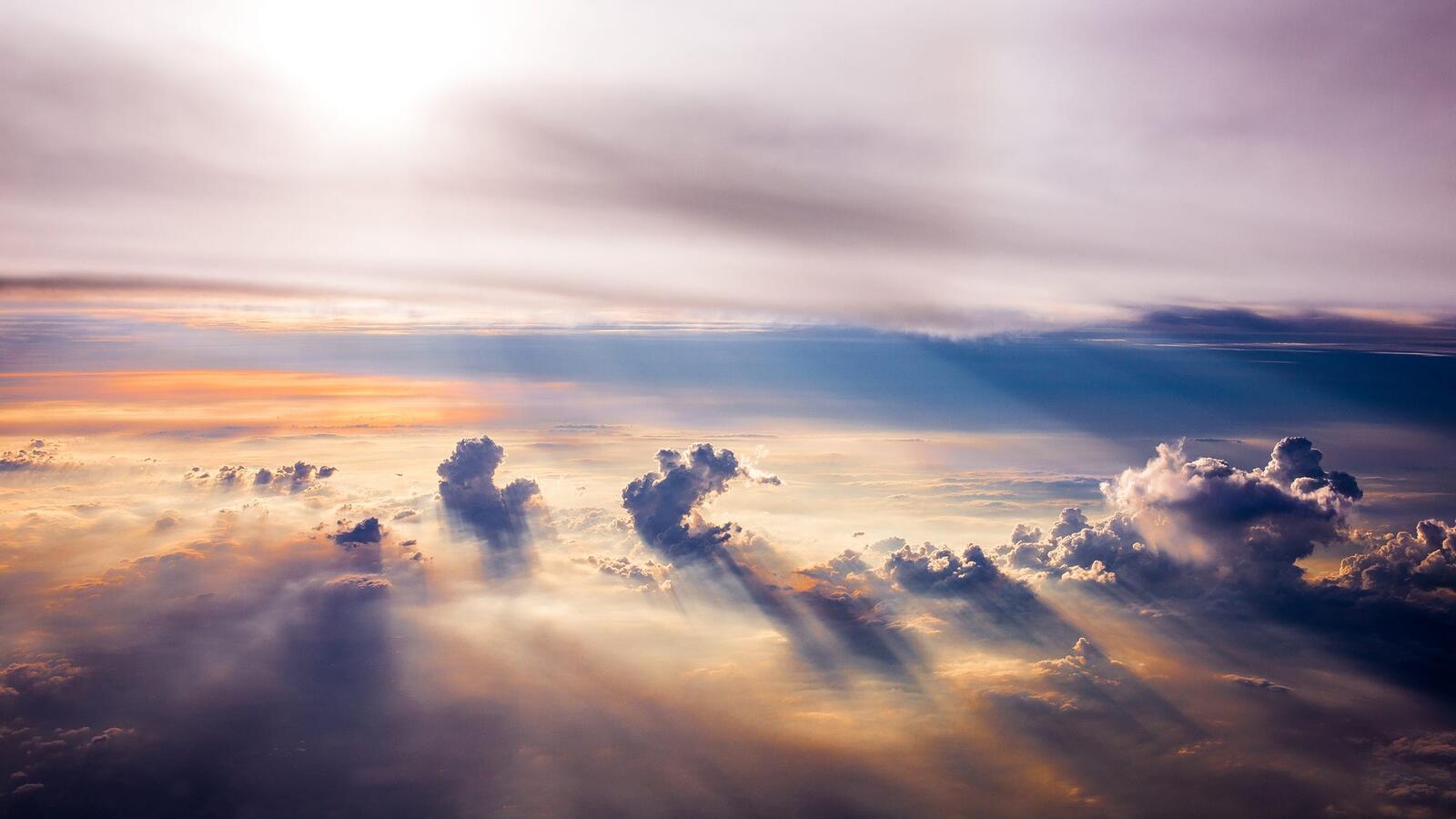 Бесплатное фото Солнечные лучи за облаками освещают поверхность неба