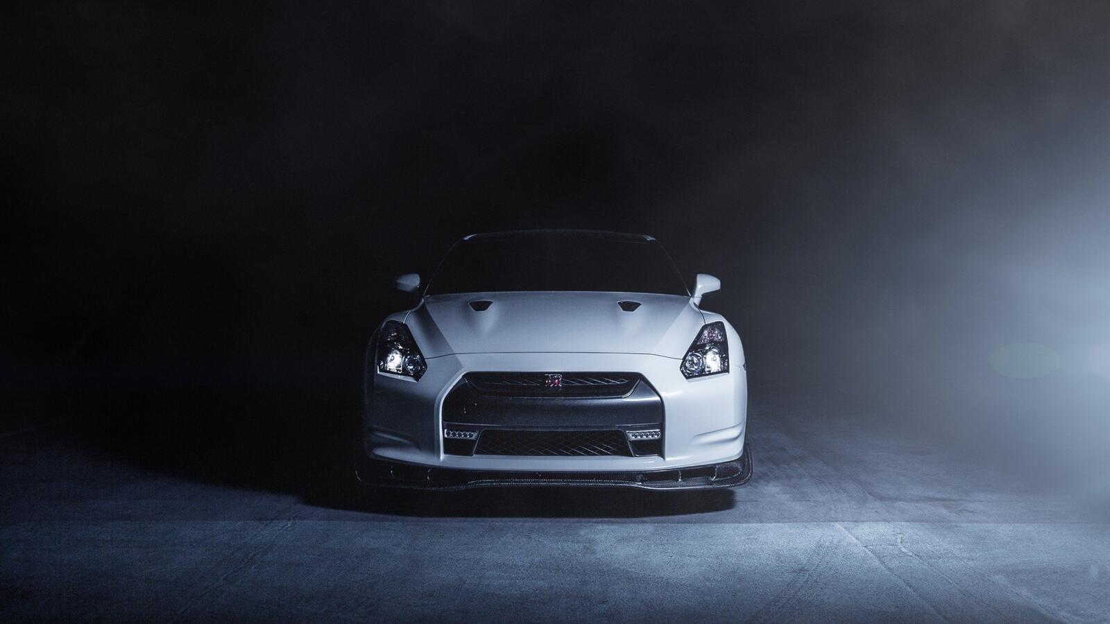 Free photo A white Nissan gtr in a smoky room.