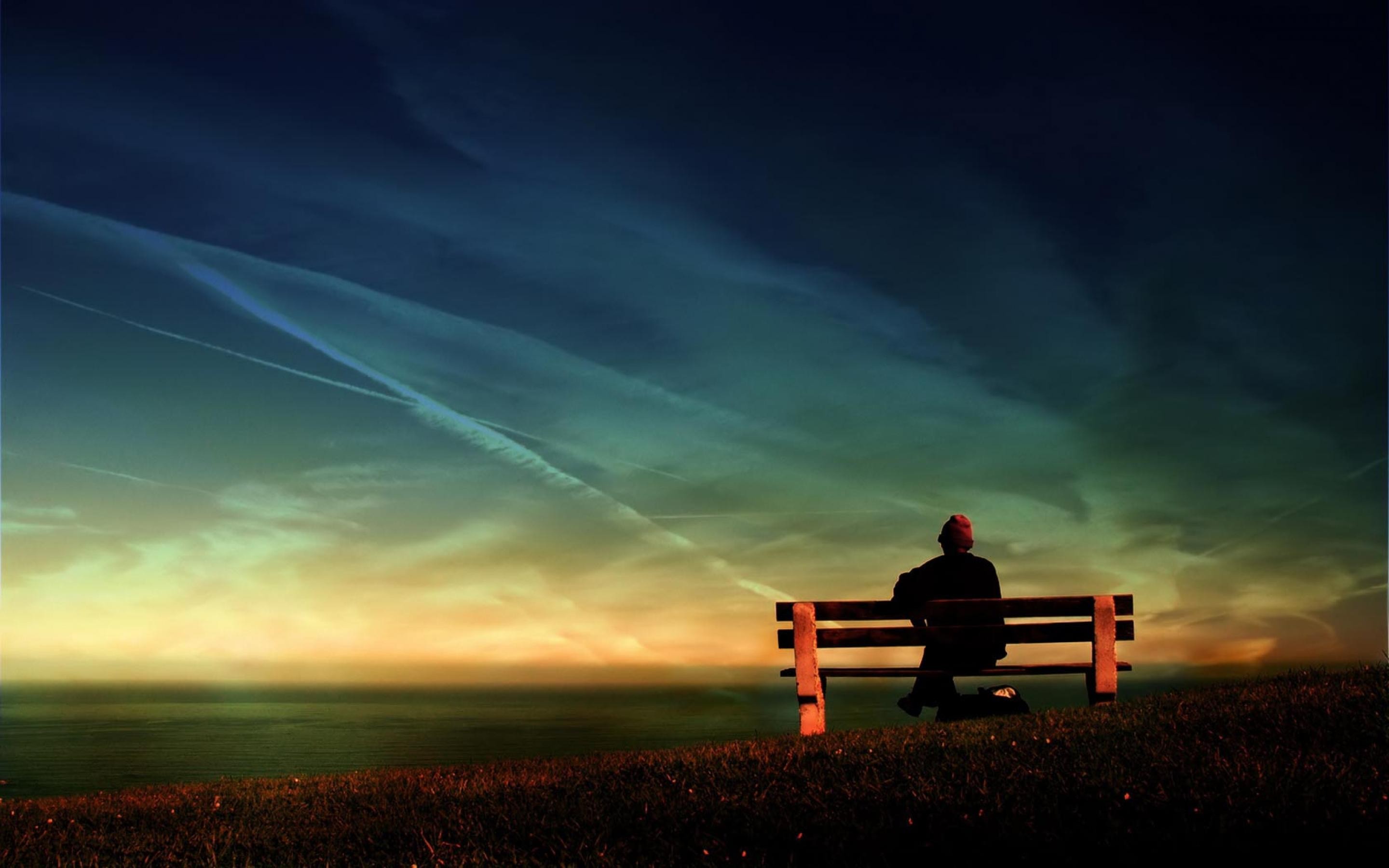 一个人坐在长椅上，凝视着虚空。