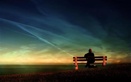 A guy sits on a bench and stares into the void.