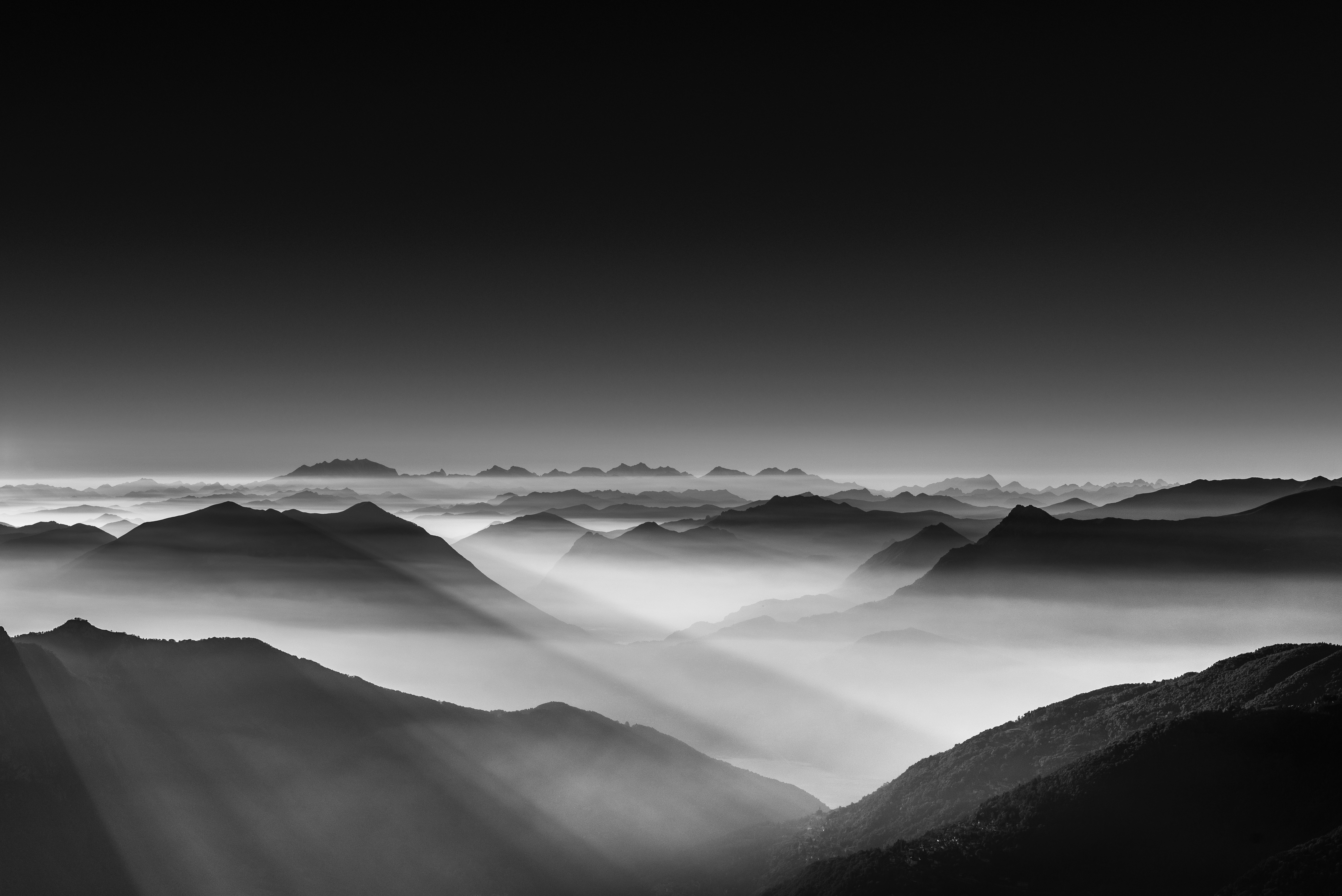 A black and white photo of the mountains from above