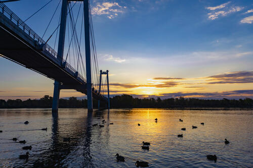 Suspension bridge over the river at dawn
