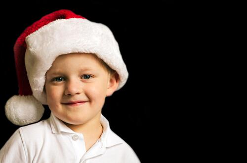 A boy in a New Year`s hat of Santa Claus.