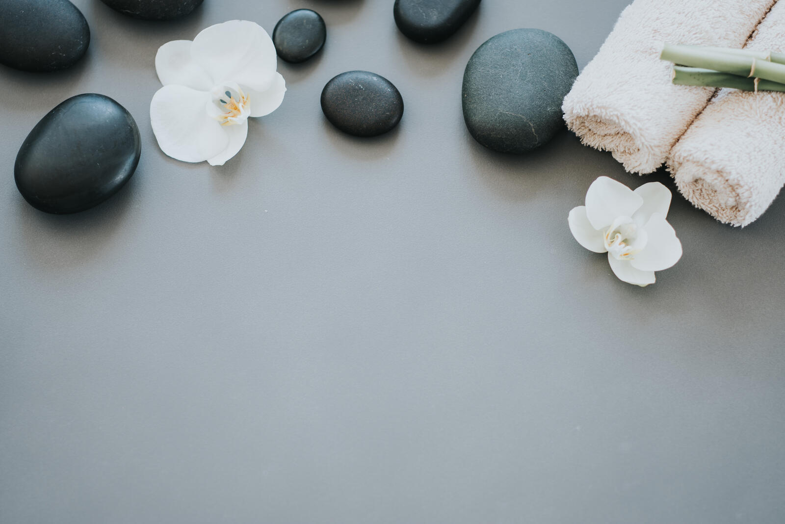 Free photo Black pebbles with flowers in the spa