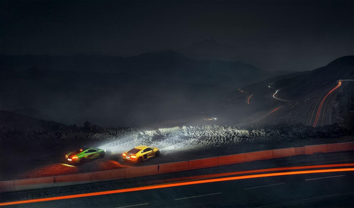McLaren and Audi r8 on a country track at night.