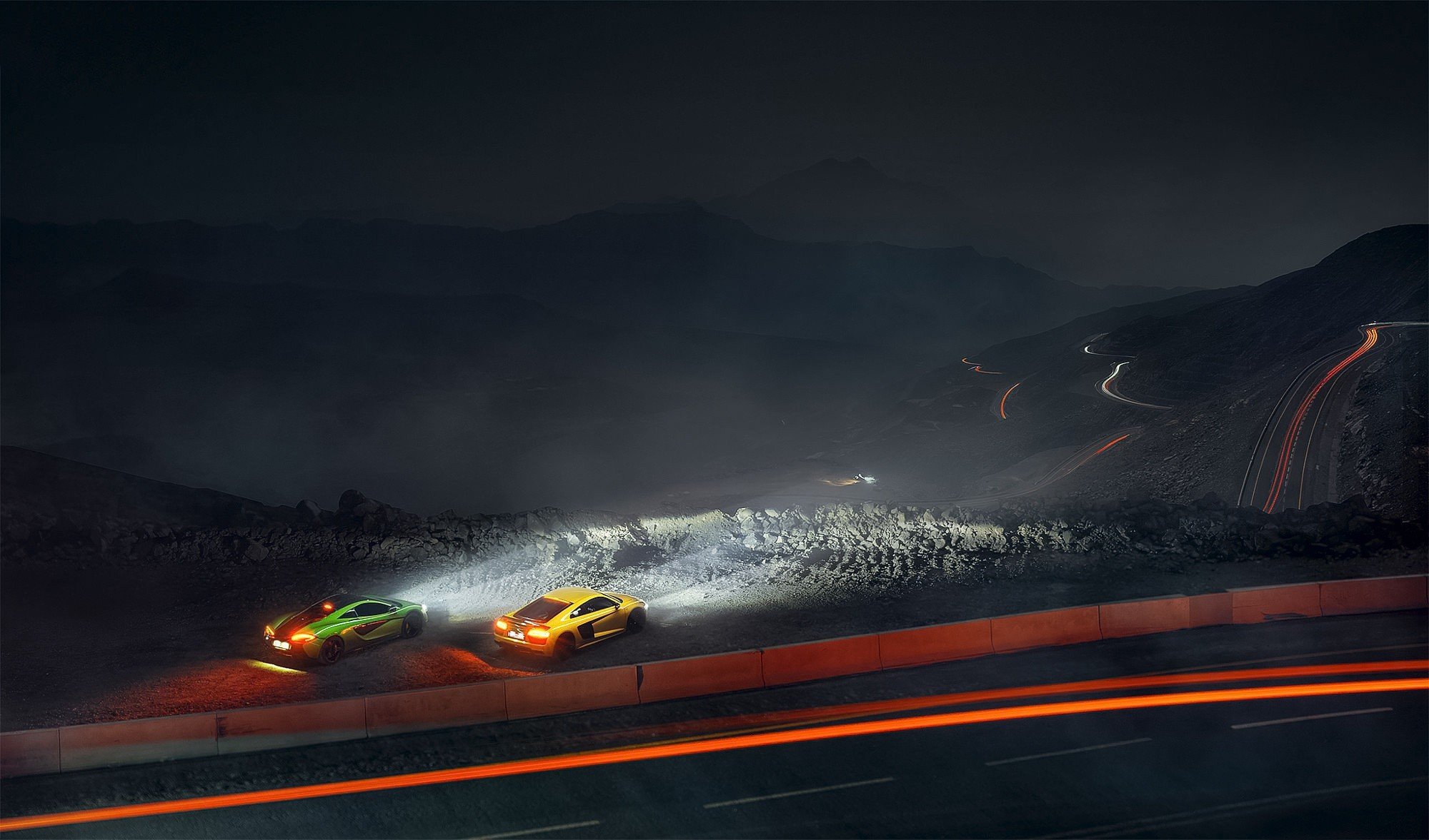 Free photo McLaren and Audi r8 on a country track at night.