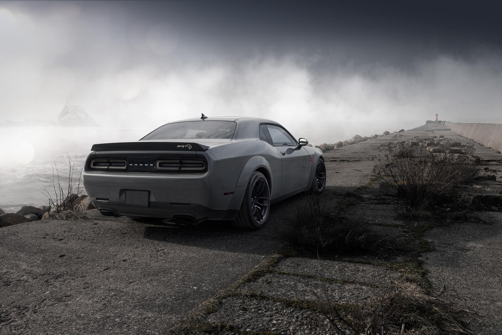 Free photo Cool Dodge Challenger in gray in foggy weather near the lighthouse