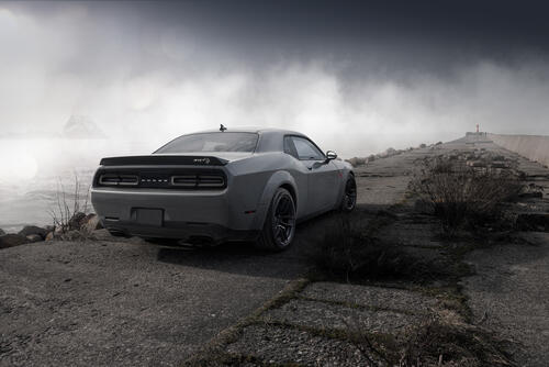 Cool Dodge Challenger in gray in foggy weather near the lighthouse