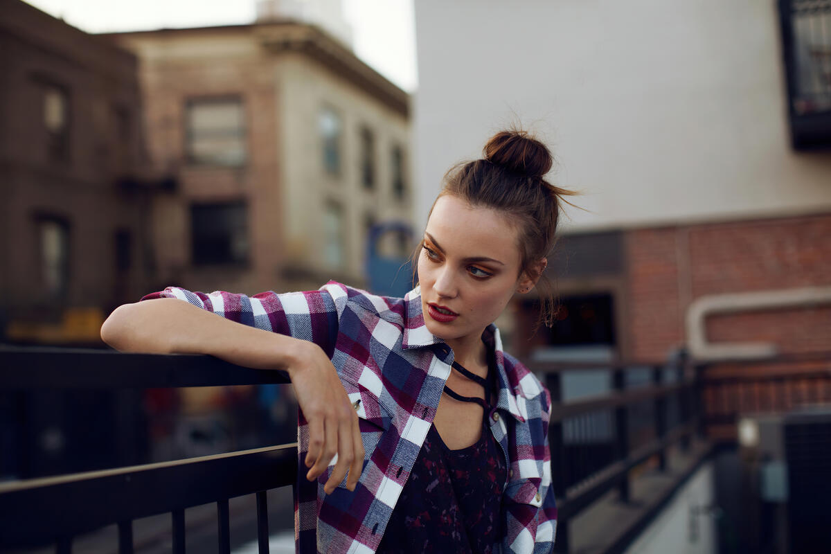 Красивая девушка в рубашке сидит на балконе
