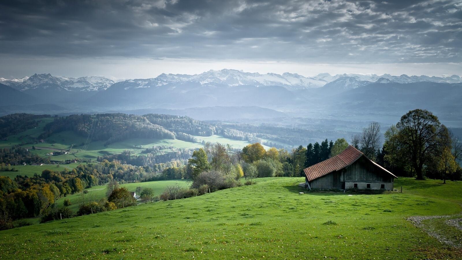 Бесплатное фото Поселок в холмистой местности на фоне гор