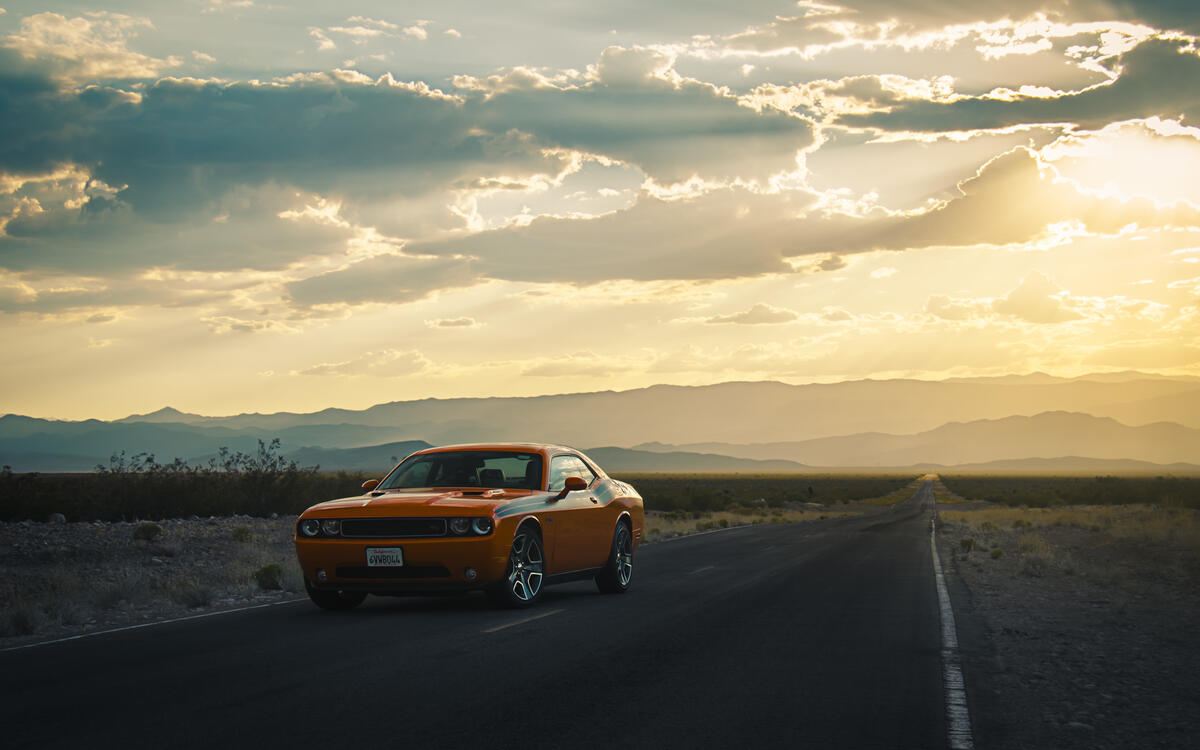 A picture of a Dodge Challenger on a deserted highway.