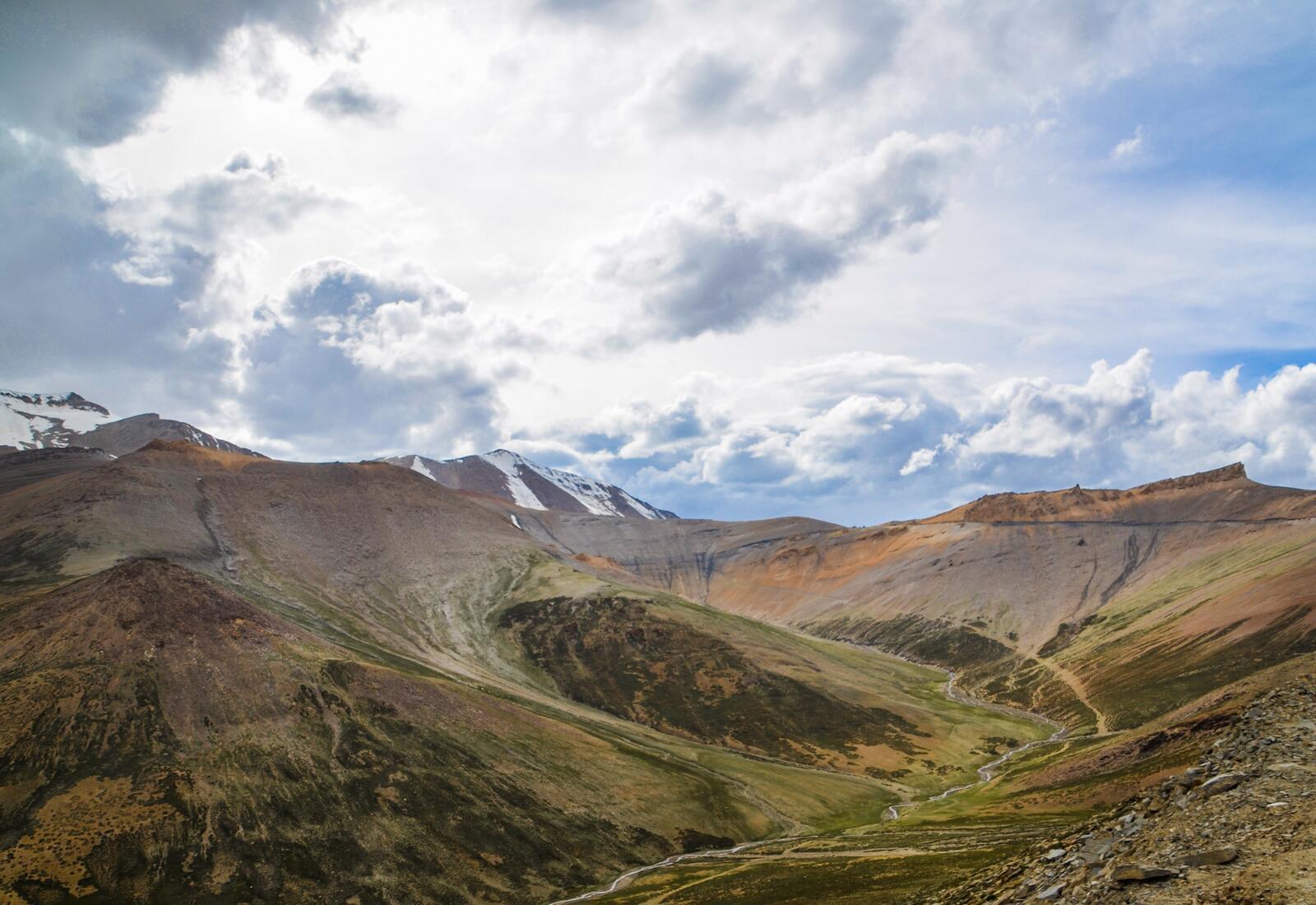 Бесплатное фото Облака над горным хребтом в долине