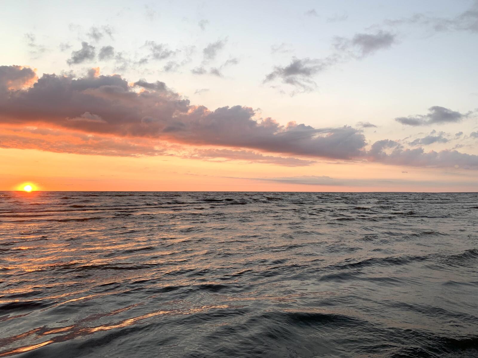 Бесплатное фото Оранжевое солнце прячется за море