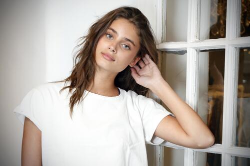 Taylor Hill in a white T-shirt at the window
