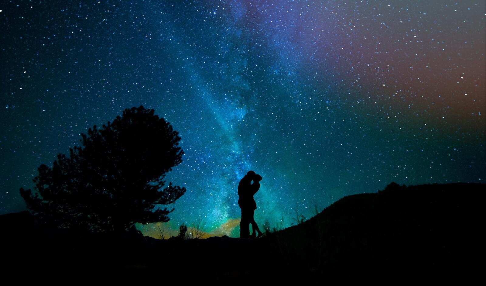 Free photo Silhouette of a young couple against a starry sky