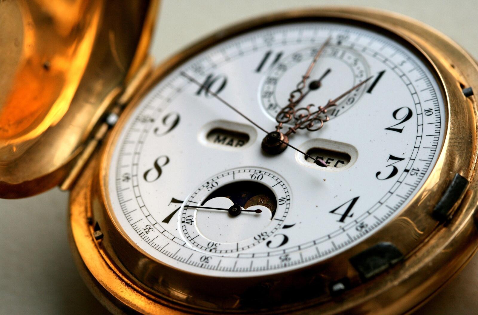 Бесплатное фото Карманные золотые часы с белым циферблатом