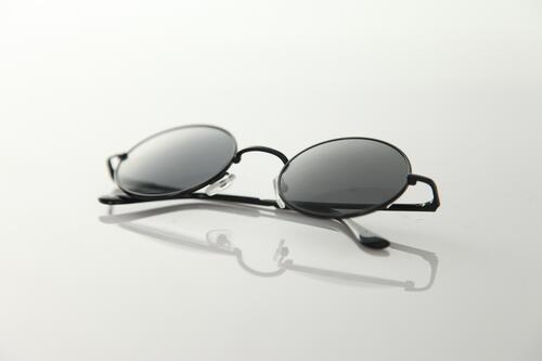 Sunglasses with round lenses on gray background