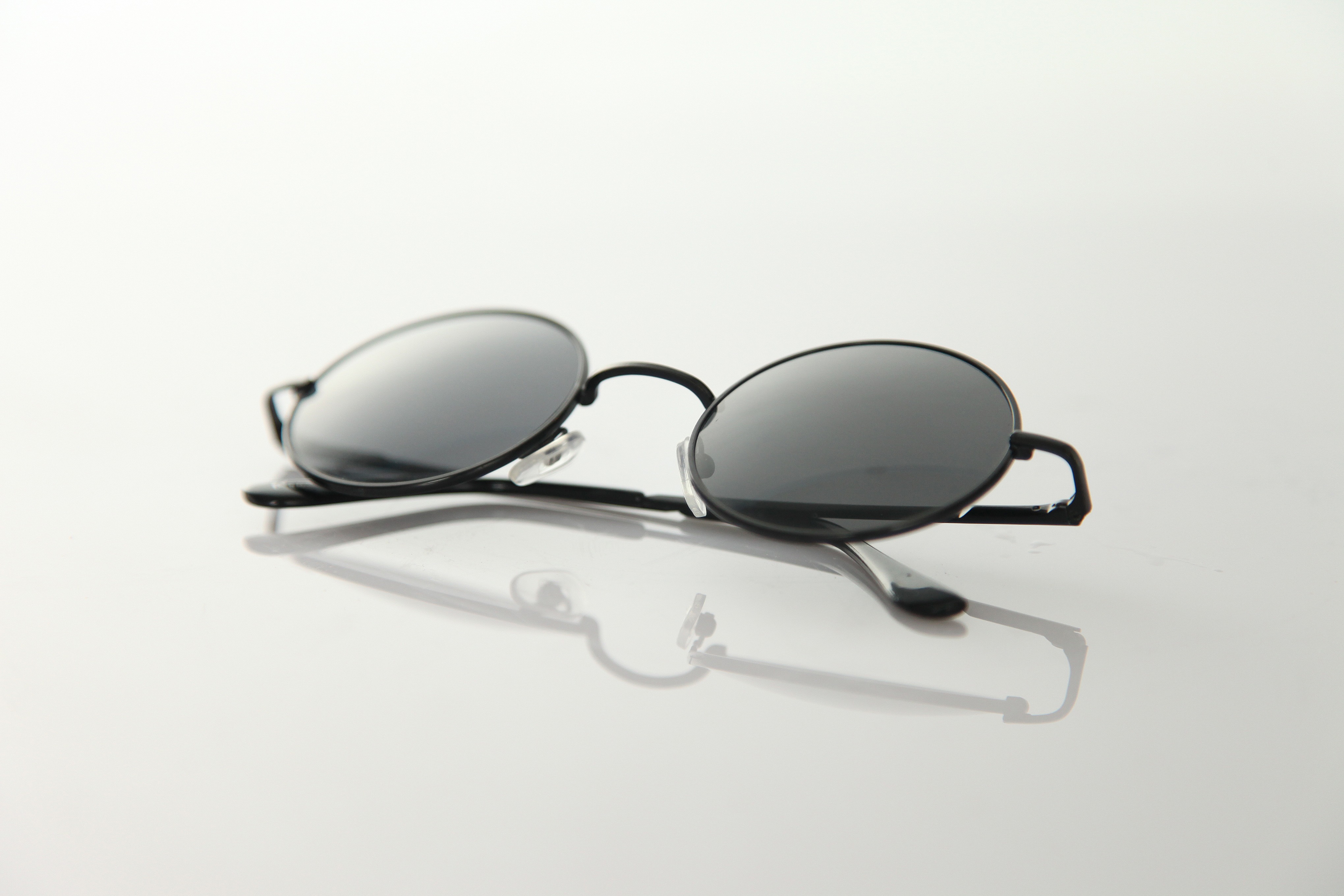 Free photo Sunglasses with round lenses on gray background
