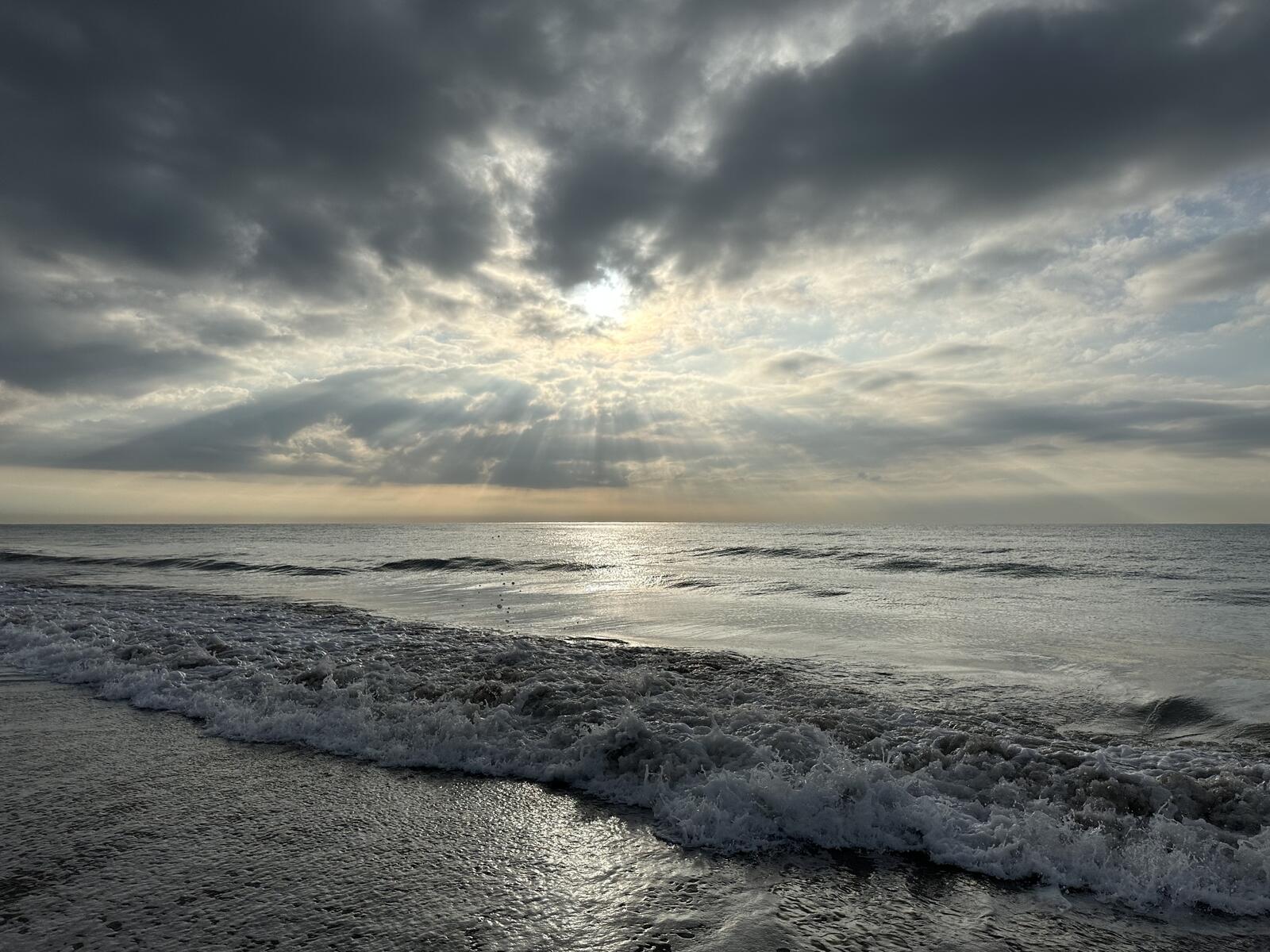 Free photo The sun in the clouds above the sea waves