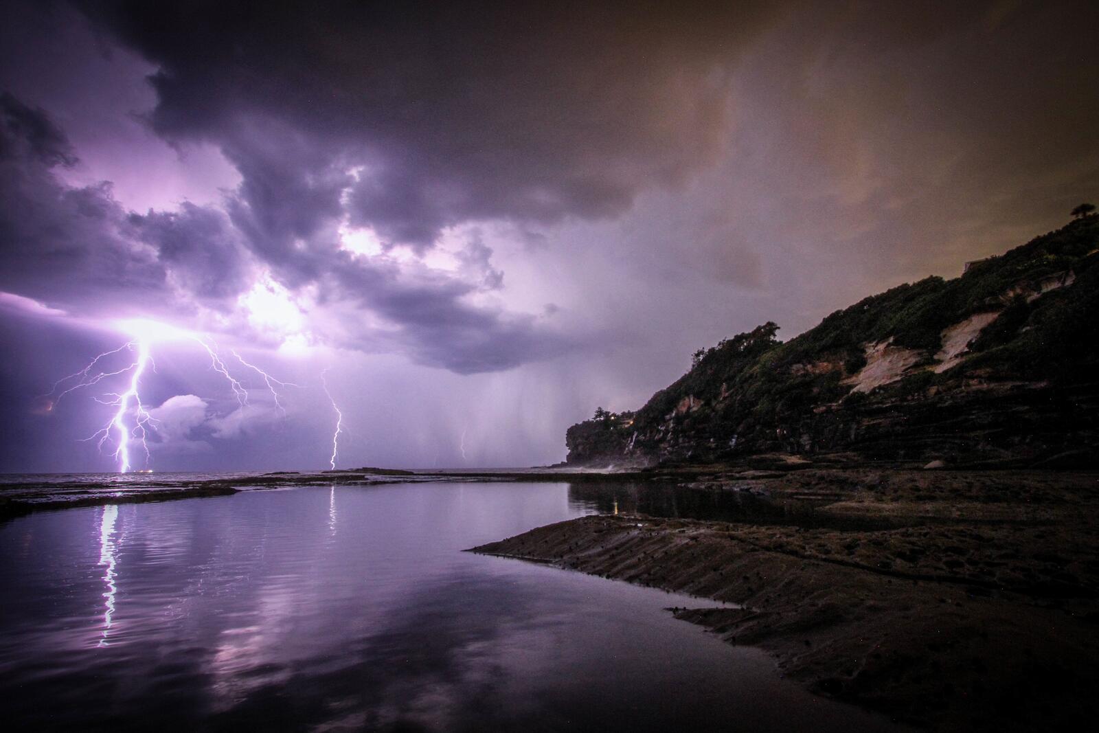 Бесплатное фото Фиолетовая молния бьет в воду