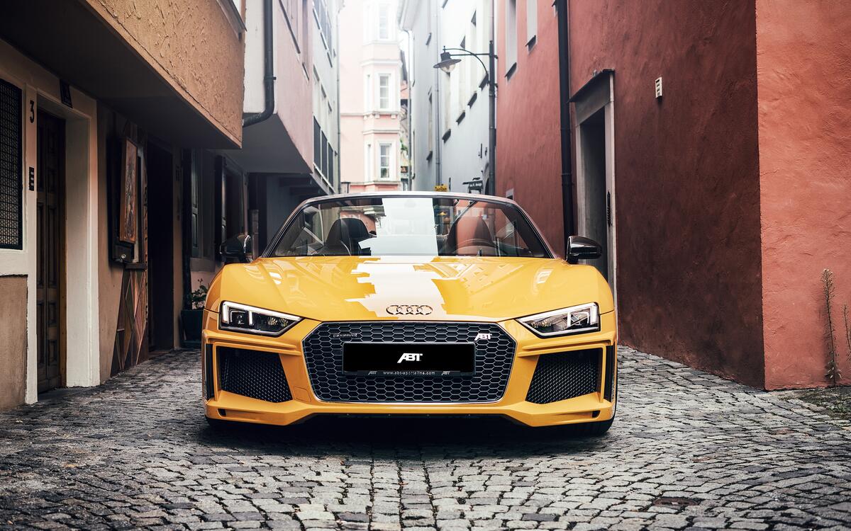 Желтый Audi R8 Spyder на узких улицах города