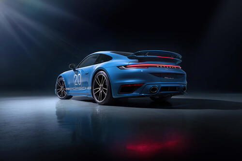 Картинка с Porsche 911 голубого цвета в темном помещении