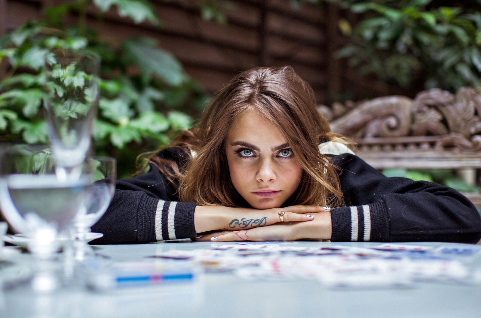 Бесплатное фото Кара Делевинь сидит за столом