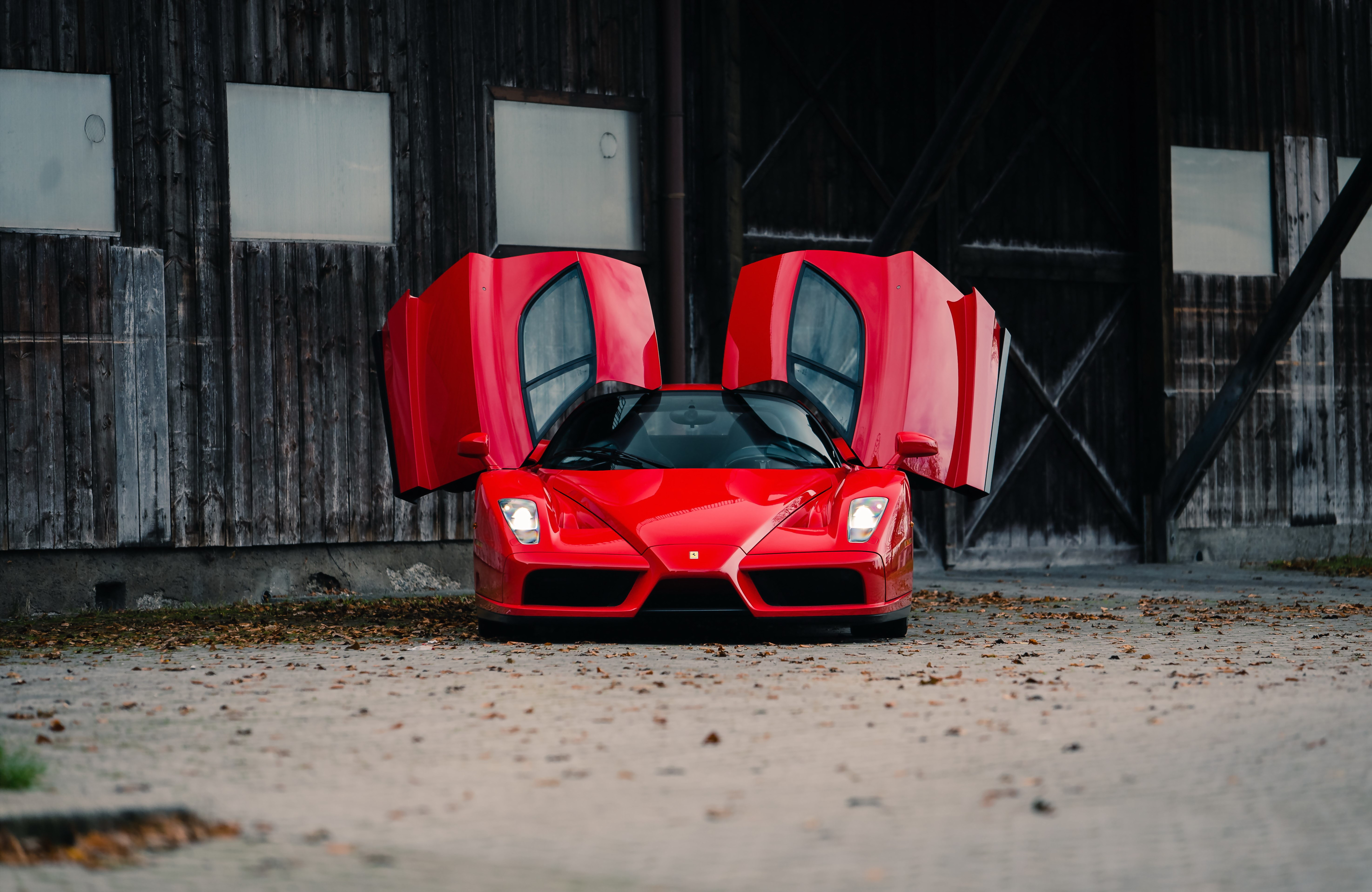 Красная Ferrari Enzo с открытыми дверями вид спереди