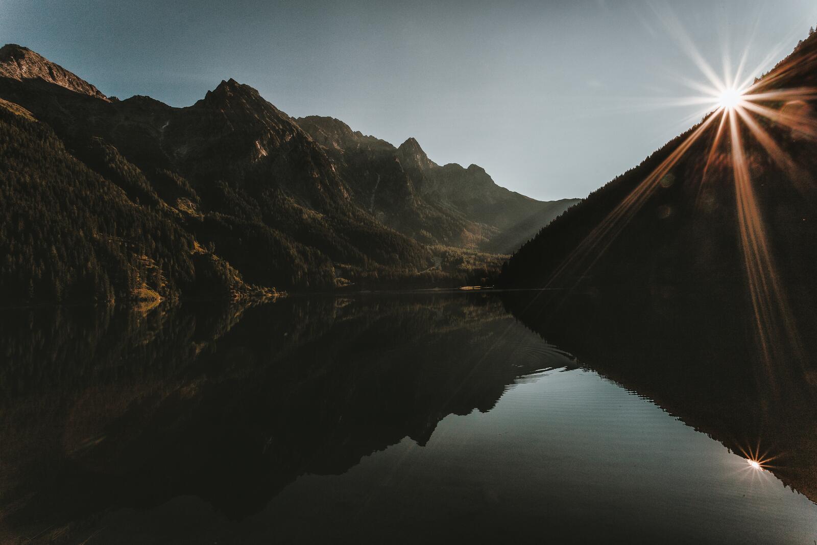 Бесплатное фото Первые солнечные лучи в горах у озера