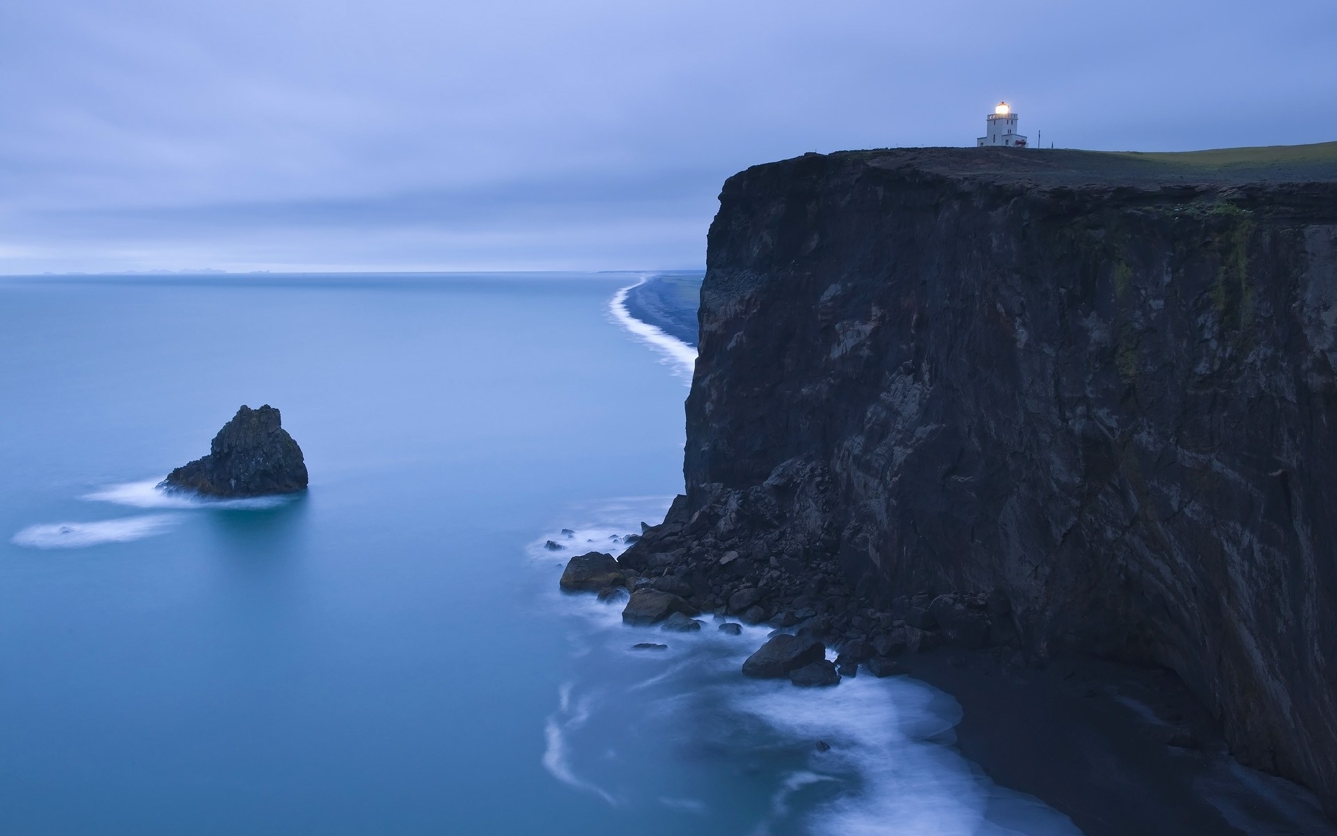 Free photo Evening lighthouse at the cliff by the ocean