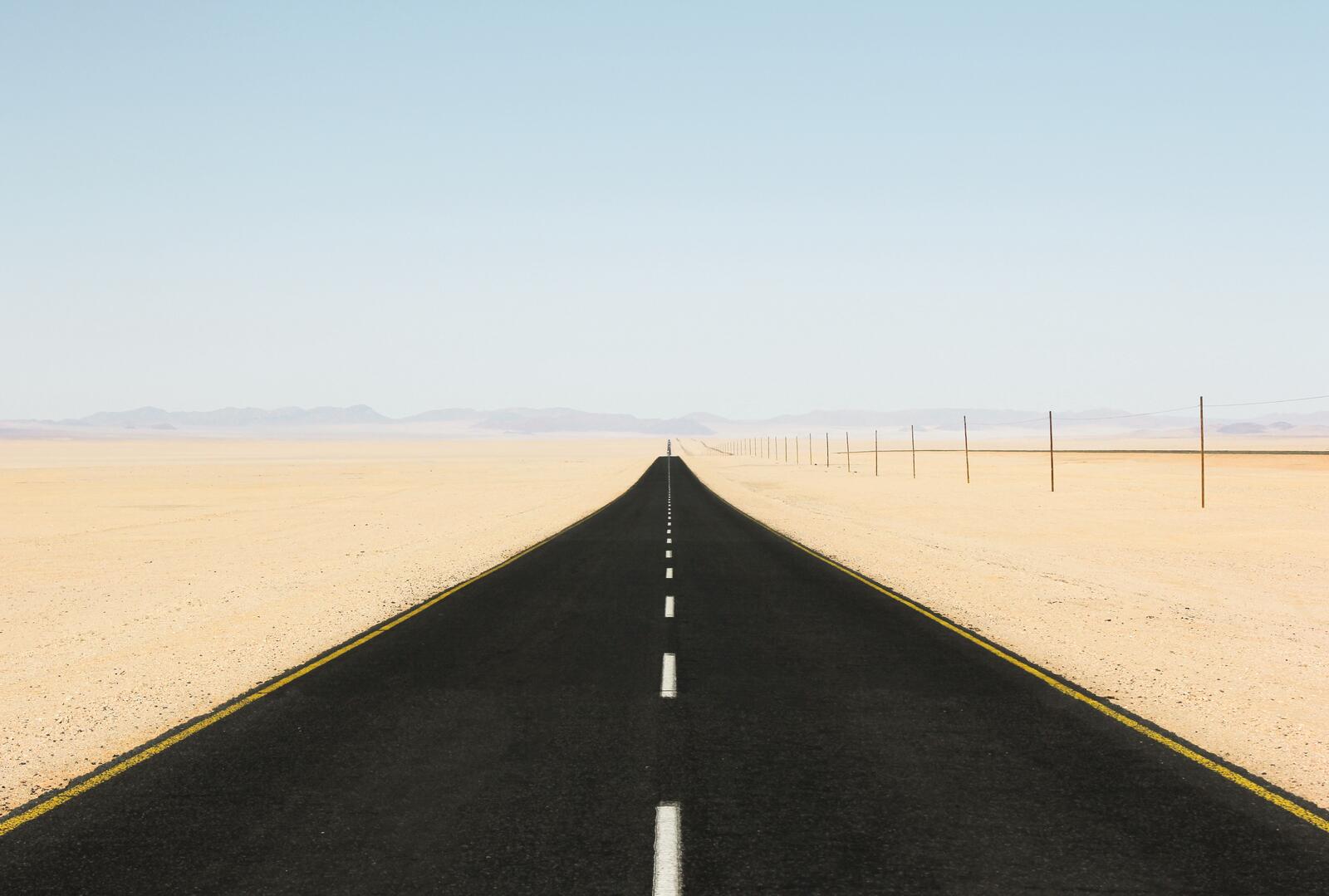 Бесплатное фото Черная дорога идущая сквозь пустыню
