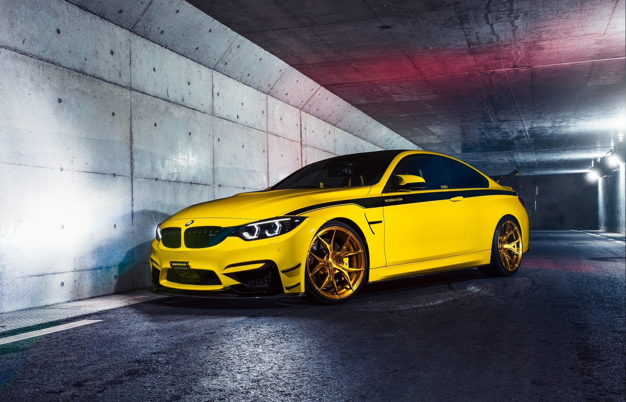 Free photo Yellow bmw m4 f82 on gold rims with a black stripe on the side