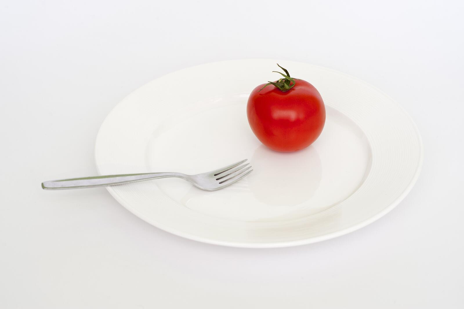 Бесплатное фото Красный помидор на белой тарелке